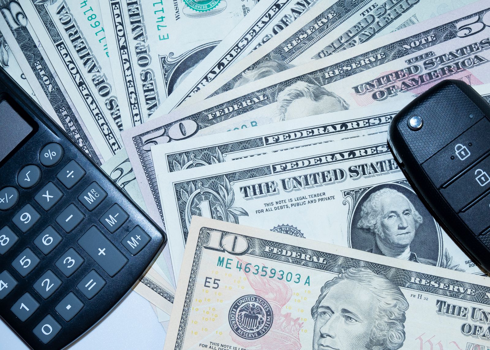 Car keys, cash and a calculator on a table